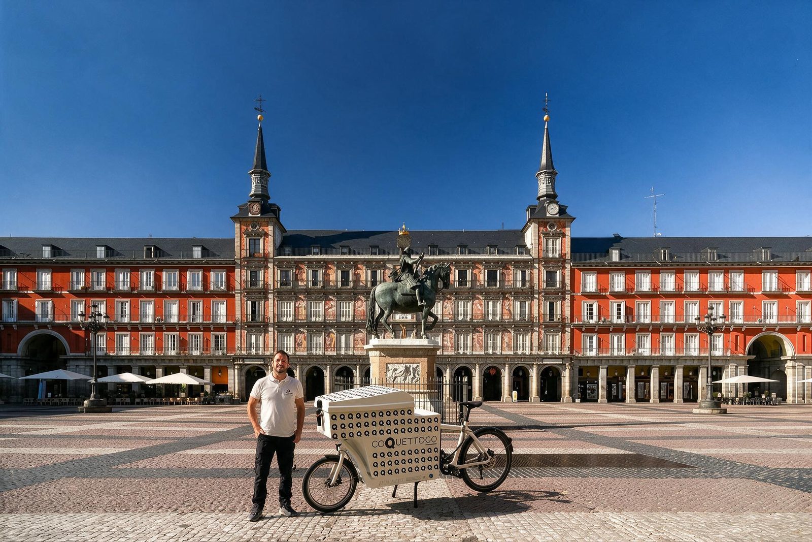 Un repartidor con un carro de CoquettoGO cruzando la Plaza Mayor de Madrid.