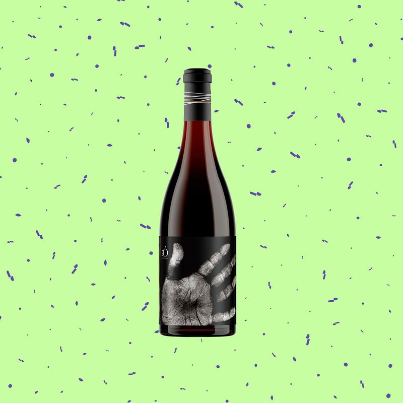 Botella de dÓrio con una mano ilustrada ocupando la etiqueta, sobre fondo verde.