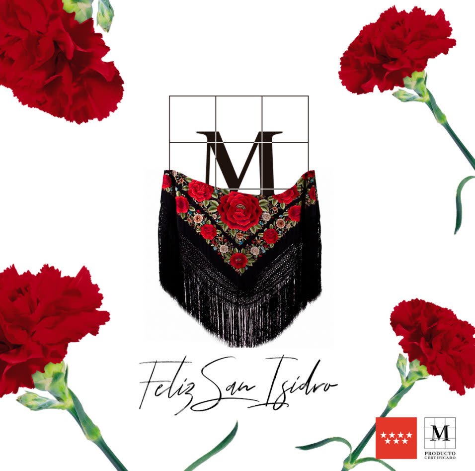 Pieza de San Isidro: el montón de la M de Producto Certificado con un mantón de Manila bordado colgando, claveles rojos en las cuatro esquinas y la firma manuscrita «Feliz San Isidro».