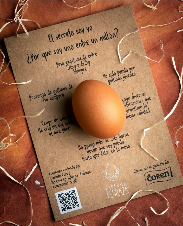 La huevera: un huevo sobre una tarjeta de cartón con el argumento escrito a rotulador en primera persona, un código QR y los sellos de Taberna Pedraza y Coren.