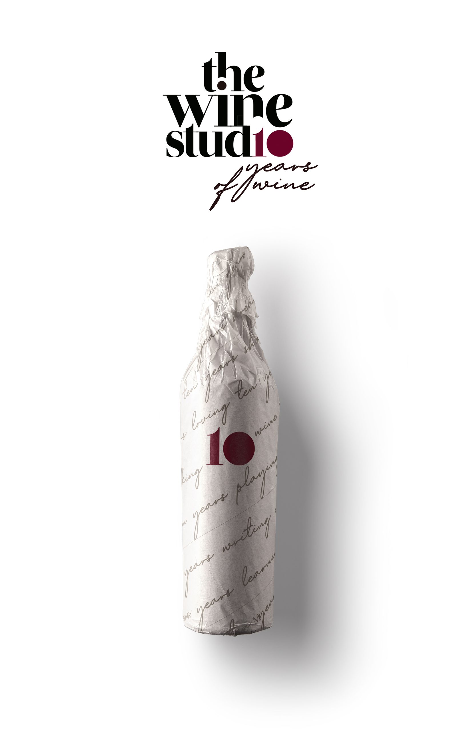 Botella envuelta en el papel manuscrito de The Wine Studio, con el 10 granate del décimo aniversario sobre el envoltorio.