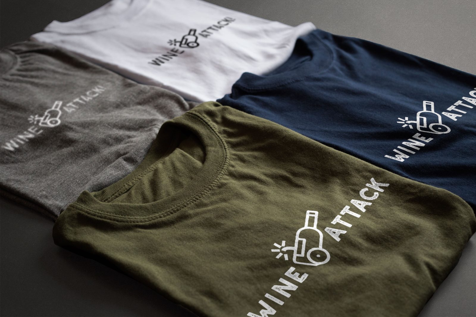 Cuatro camisetas —blanca, gris, caqui y azul marino— con el logotipo de Wine Attack serigrafiado a una tinta.